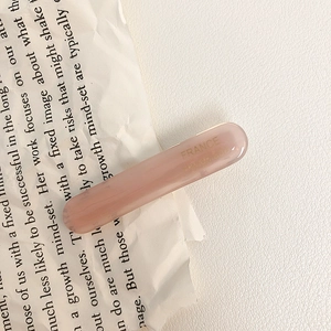 Detail of handmade acetate hair clip in translucent pink with France engraving on book