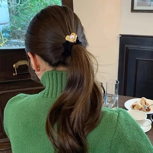 Detail of elegant black velvet hair tie with pearl heart charm on ponytail