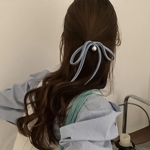 Light blue bow hair tie with pearl pendant on long hair for elegant French style
