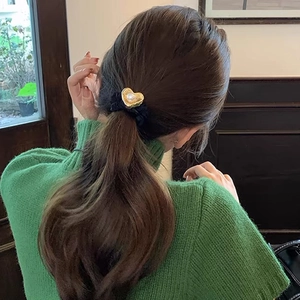Elegant black velvet scrunchie with a gold pearl heart pendant on a ponytail