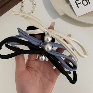 Detail showing set of three satin bow hair ties with large pearls in black, white and blue