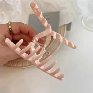 Detailed view of pink matte hair claw clip showing spring mechanism and multi-teeth design