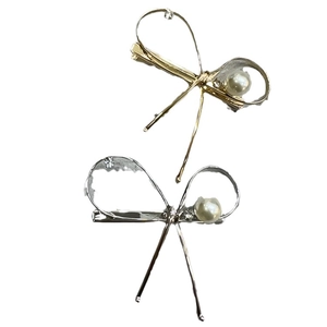 Elegant gold and silver metal bow hair clips with pearls and rhinestones on white background