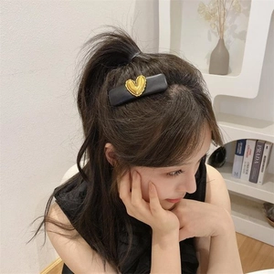 Vintage black PU leather sponge hair clip with embossed gold heart worn by a model