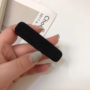 Barrette élégante en satin noir tenue à la main avec un style français rétro minimaliste