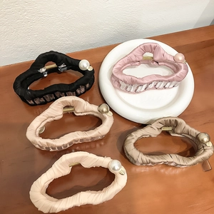 Détail de pinces à cheveux élégantes en tissu ondulé avec perles sur bois