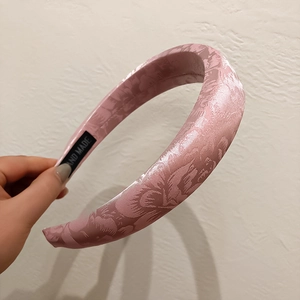 Close-up of pink jacquard headband with damask pattern and handmade label tag