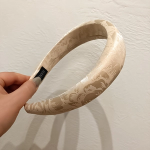 Close-up of beige jacquard flower headband with luxury sponge padding and handmade label