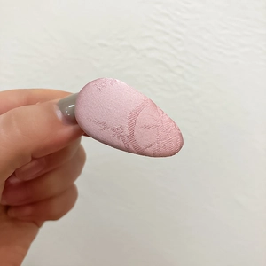 Detail of pink jacquard fabric hair clip with luxury floral pattern texture