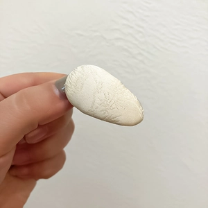 Close-up of jacquard fabric pattern on a beige drop-shaped hair clip for women