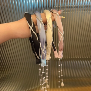 Detail von vierteiligen Perlenfransen-Stirnbändern in den Farben Schwarz, Blau und Rosa