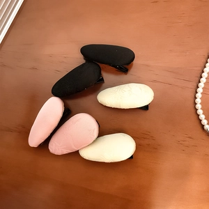 Close-up of 6-piece jacquard fabric hair clips set in black pink and cream beige