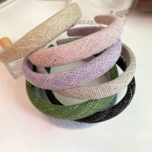 Close-up of assorted tweed headbands with metallic threads and textured woven fabric