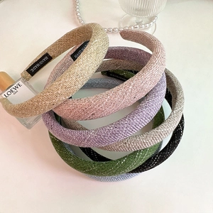 Close-up of handmade tweed headbands in various colors with pearls and vintage decor