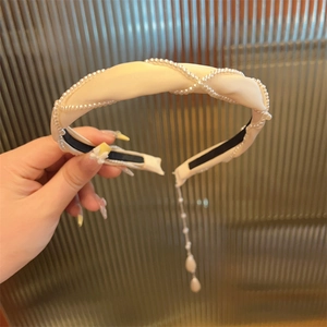 Detailansicht eines cremefarbenen Satin-Haarreifs mit Perlennetz und langer Quastenkette