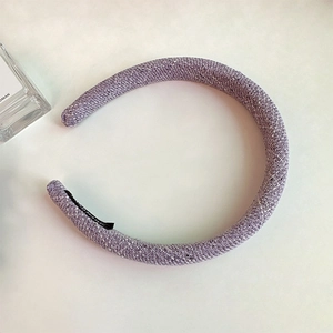 Detailed texture of purple tweed woven headband with thick sponge padding for volume