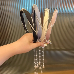 Detailansicht von vier Satin-Haarreifen mit eleganten langen Perlen-Fransen-Anhängern