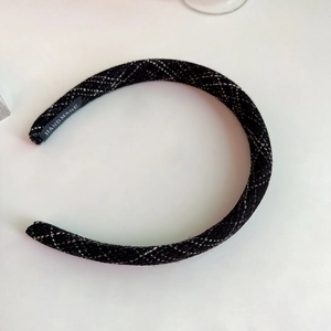 Detail of handmade black tweed headband with silver woven diamond pattern and inner label
