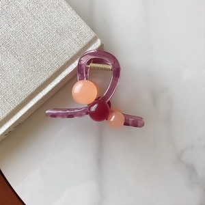 Pince à cheveux élégante violette translucide avec perles sur fond de marbre