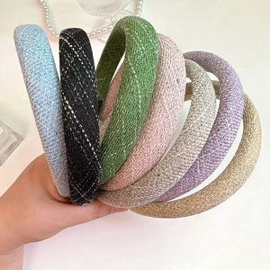 Close-up of assorted plaid tweed padded headbands in various stylish pastel colors