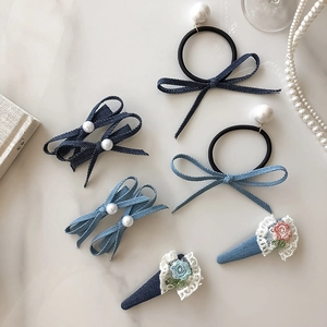 Denim haarspelden met geborduurde bloemen en kanten rand op een marmeren ondergrond
