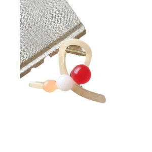 Pince à cheveux crème élégante avec perles colorées sur un fond blanc pur