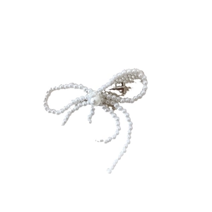Eleganter Haarclip mit weißen Perlen in Schleifenform und Metall-Federclip auf weißem Grund