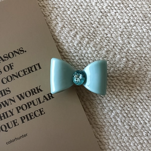 Détail de la pince à cheveux noeud bleu clair ornée d'une pierre précieuse en cristal
