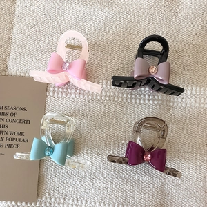 Vue détaillée de pinces à cheveux en forme de nœud en quatre couleurs avec pierres gemmes