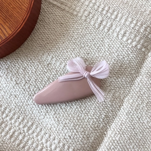 Sweet pink bow teardrop hair clip for women on a cream woven background