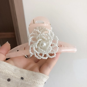 Grande molletta per capelli in acrilico rosa con fiore di perle intrecciate in dettaglio