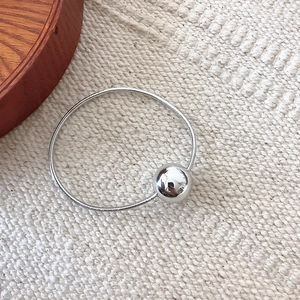 Close-up of a silver mirror-finish metal bead on a high-elasticity metallic cord band