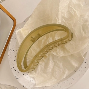 Detailed view of large crescent hollow hair claw clip in translucent olive green