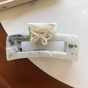 Elegante molletta per capelli in acetato marmorizzato con fiocco di perle