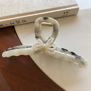 Elegante pinza per capelli marmorizzata con fiocco di perle bianche e molla dorata