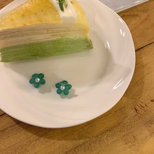 Vue détaillée de deux petites pinces à cheveux fleurs vertes avec perles sur assiette