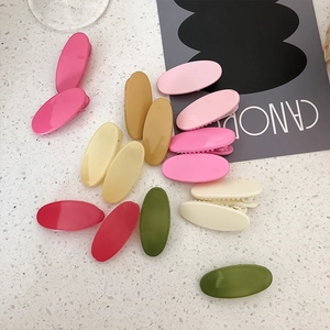 Colorful oval candy-colored hair clips set on marble background for girls