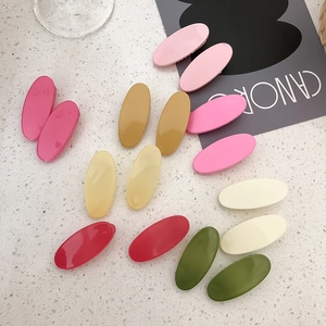Set of colorful oval candy-colored hair clips for girls on a white stone background
