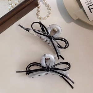 Elegant grey marble bow hair claw clips set shown with decorative pearls and wooden tray