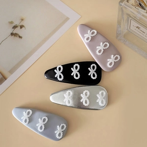 Set de cuatro pinzas para el cabello de cuero sintético con lazos de perlas blancas y azul