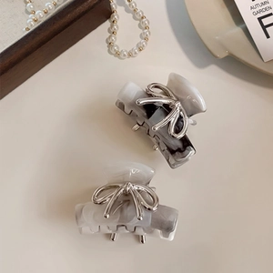 Elegant silver bow hair clips with marble texture resin in a vintage aesthetic layout
