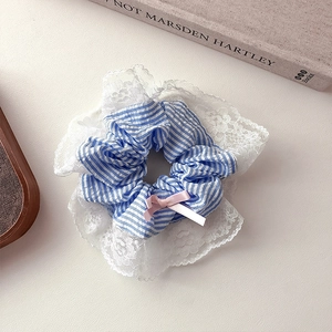 Chouchou élégant à rayures bleues avec dentelle et nœud rose sur fond minimaliste