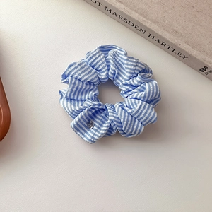 Chouchou rayé bleu et blanc avec pendentif argenté pour une coiffure élégante