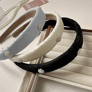 Detail of floral embroidery and pearl accents on elegant sponge headbands set