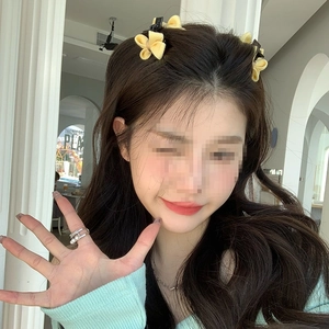 Détail de pinces à cheveux à nœud jaune vif avec bague élégante ornée de perles fines