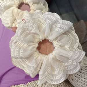 Lot de chouchous en dentelle blanc cassé avec bords crochetés portés au poignet