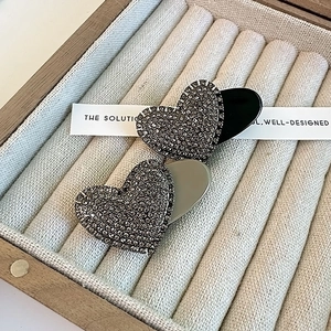 Detail of heart-shaped hair clips with sparkling rhinestones in a velvet jewelry box