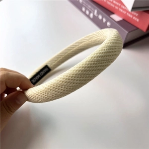 Detailed close-up of cream waffle-weave texture and handmade label on the headband