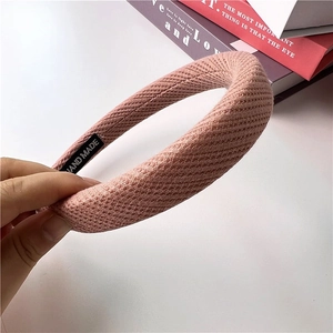 Close-up of pink waffle knit headband showing thick padding and a hand made label