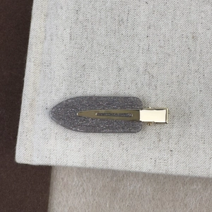 Détail d'une barrette à cheveux grise scintillante de 6 cm avec base dorée en bec de canard